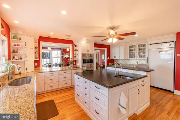 a kitchen with stainless steel appliances granite countertop a sink a stove and a refrigerator