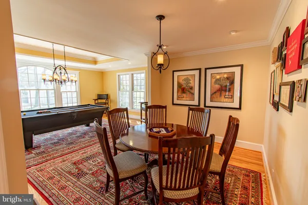 a view of a dining room with furniture a chandelier and wooden floor