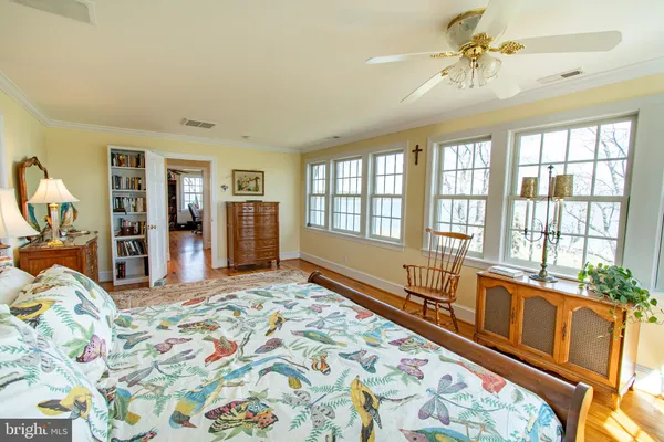 a spacious bedroom with a large bed and a chandelier
