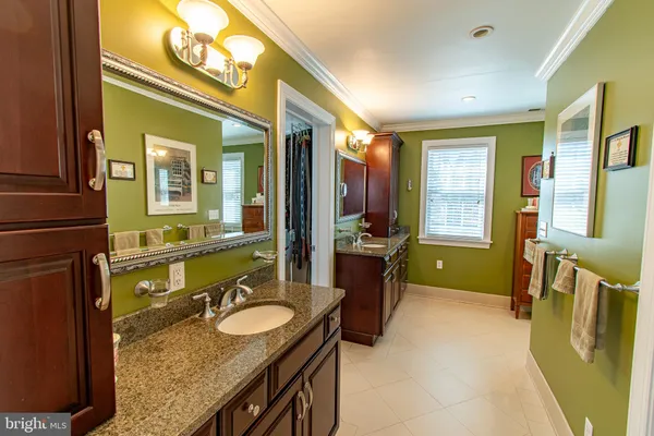 a bathroom with a granite countertop tub sink and mirror