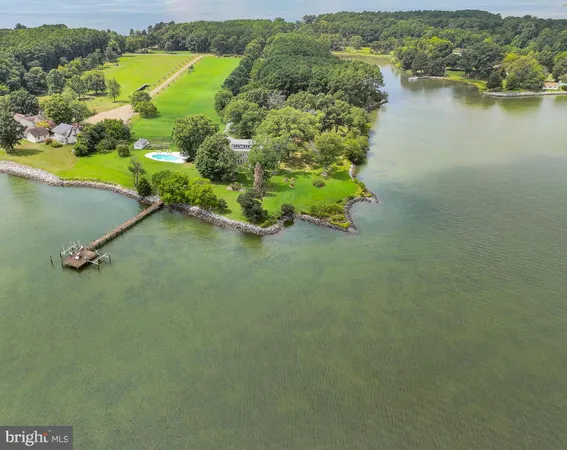 an aerial view of a house with a yard and lake view