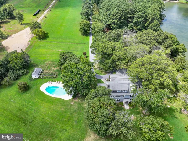 an aerial view of a house with a yard and lake view