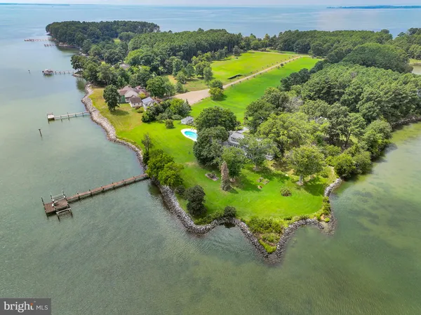 an aerial view of a house with a yard and lake view