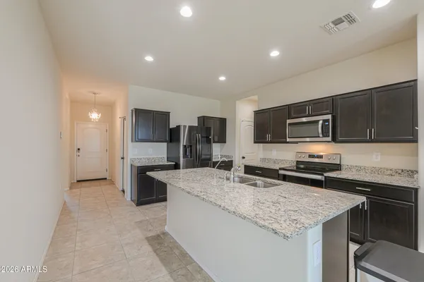 a kitchen with stainless steel appliances granite countertop a sink stove and refrigerator