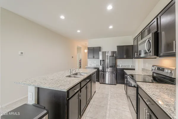a kitchen with stainless steel appliances granite countertop a sink stove and refrigerator