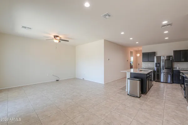 a view of a kitchen with stainless steel appliances kitchen island granite countertop a sink and cabinets