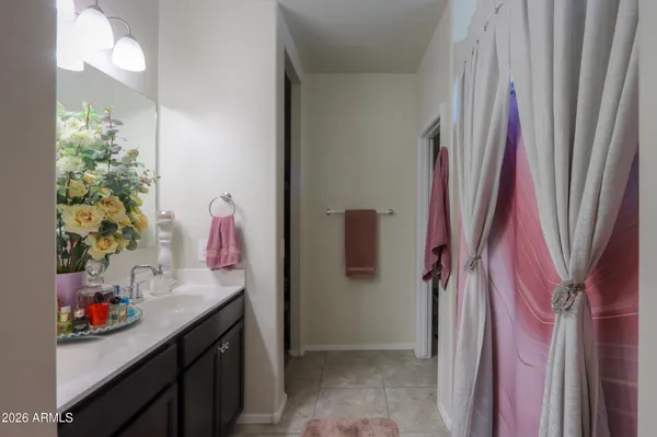 a bathroom with a sink vanity and shower curtain