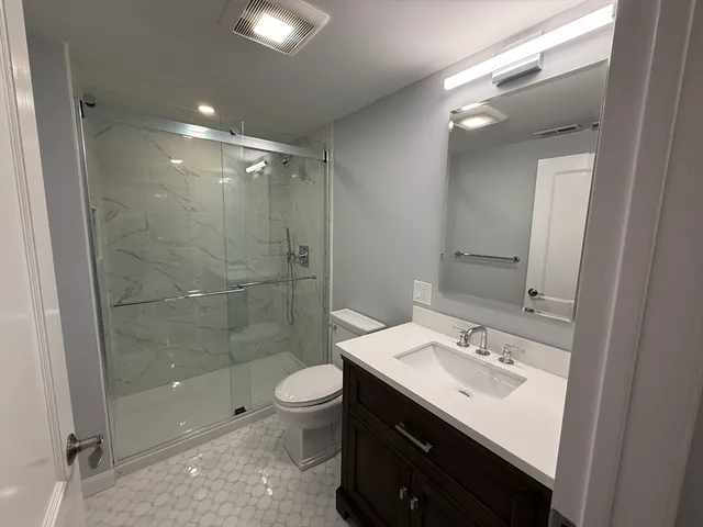 a bathroom with a sink shower and a mirror