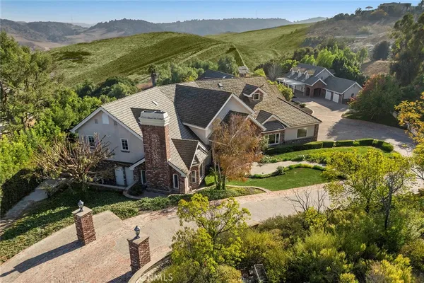 an aerial view of residential houses with outdoor space and trees