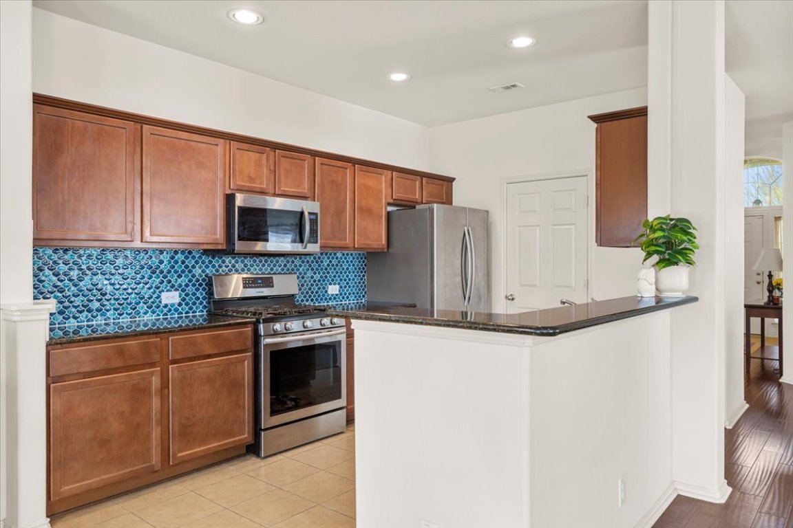 12500 Timber Heights Drive Austin, TX 78754 - Photo 10 of 31 a kitchen with stainless steel appliances white cabinets and a refrigerator