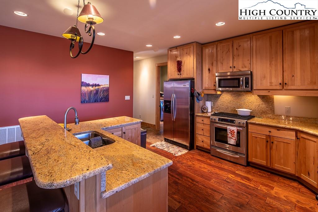 612 Bear Cubs Trail Boone, NC 28607 - Photo 14 of 37 a kitchen with stainless steel appliances granite countertop a sink refrigerator and cabinets