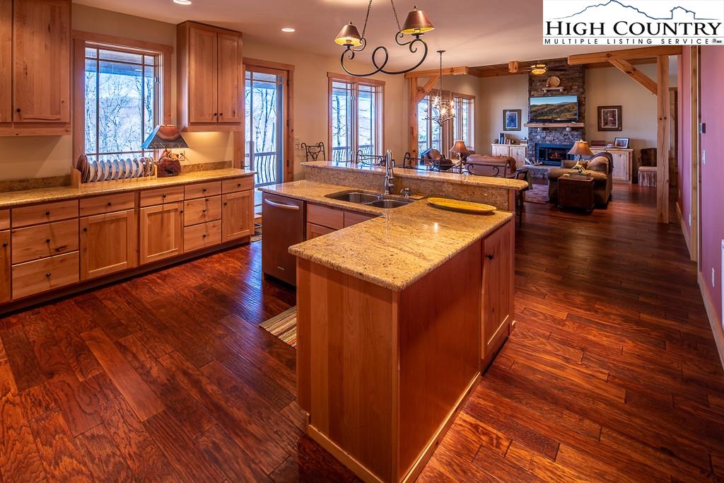 612 Bear Cubs Trail Boone, NC 28607 - Photo 15 of 37 a large living room with kitchen island granite countertop wooden floors and a sink