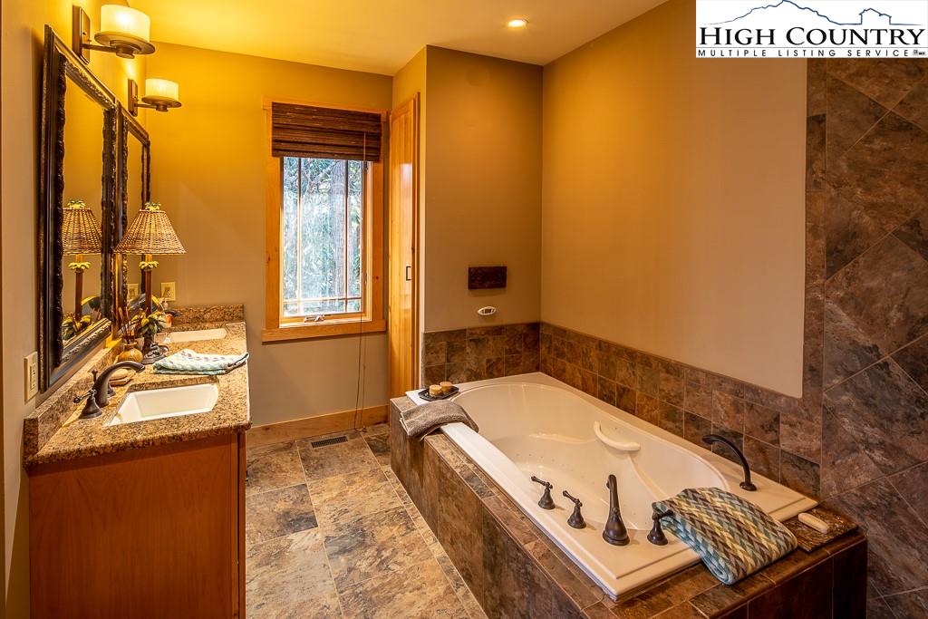 612 Bear Cubs Trail Boone, NC 28607 - Photo 20 of 37 a bathroom with a tub a sink and a large mirror
