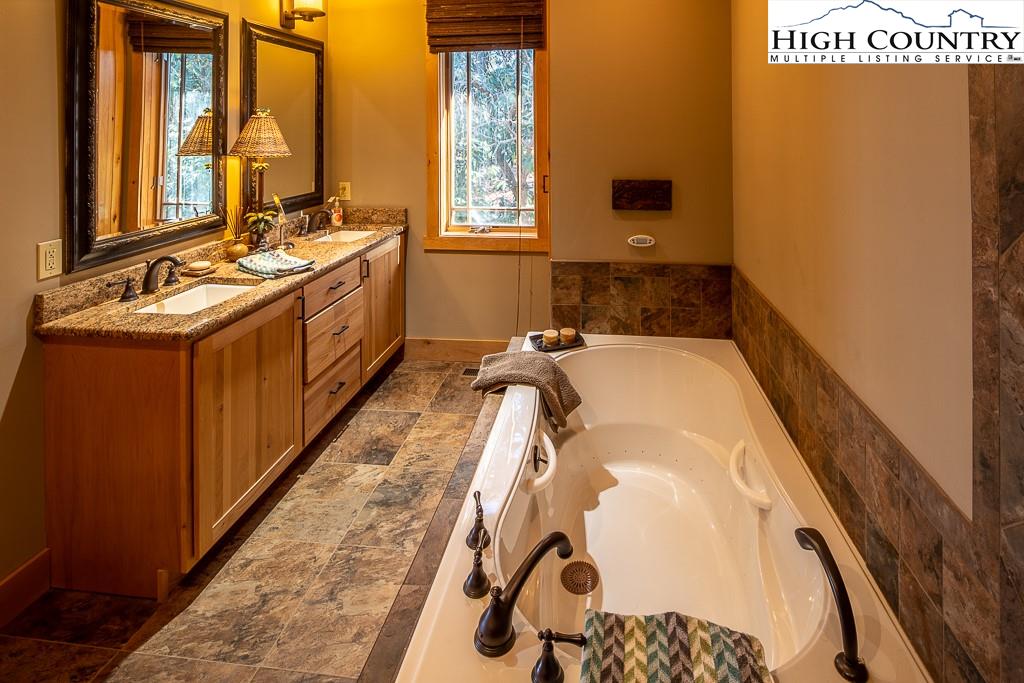 612 Bear Cubs Trail Boone, NC 28607 - Photo 21 of 37 a bathroom with a tub sink and mirror