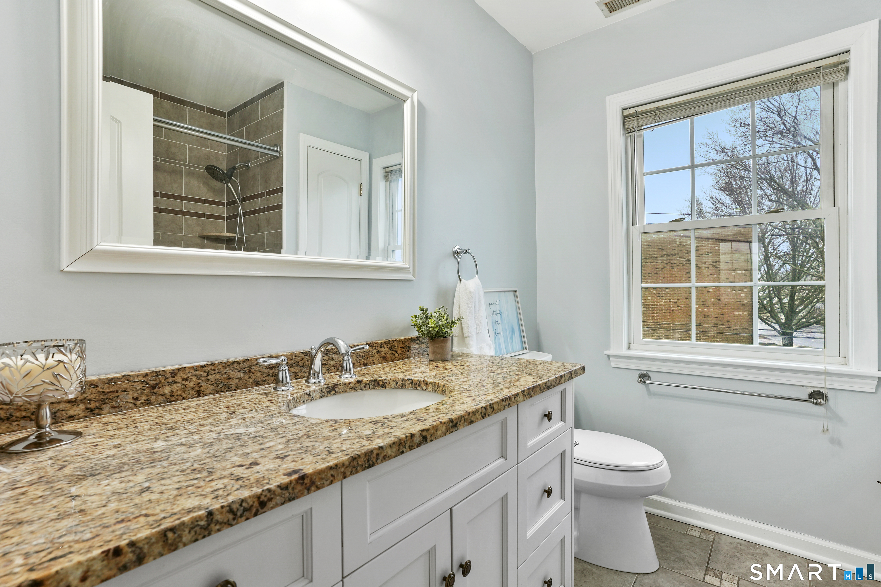 1180 Main Street Stratford, CT 06615 - Photo 12 of 22 a bathroom with a granite countertop sink a toilet and a window
