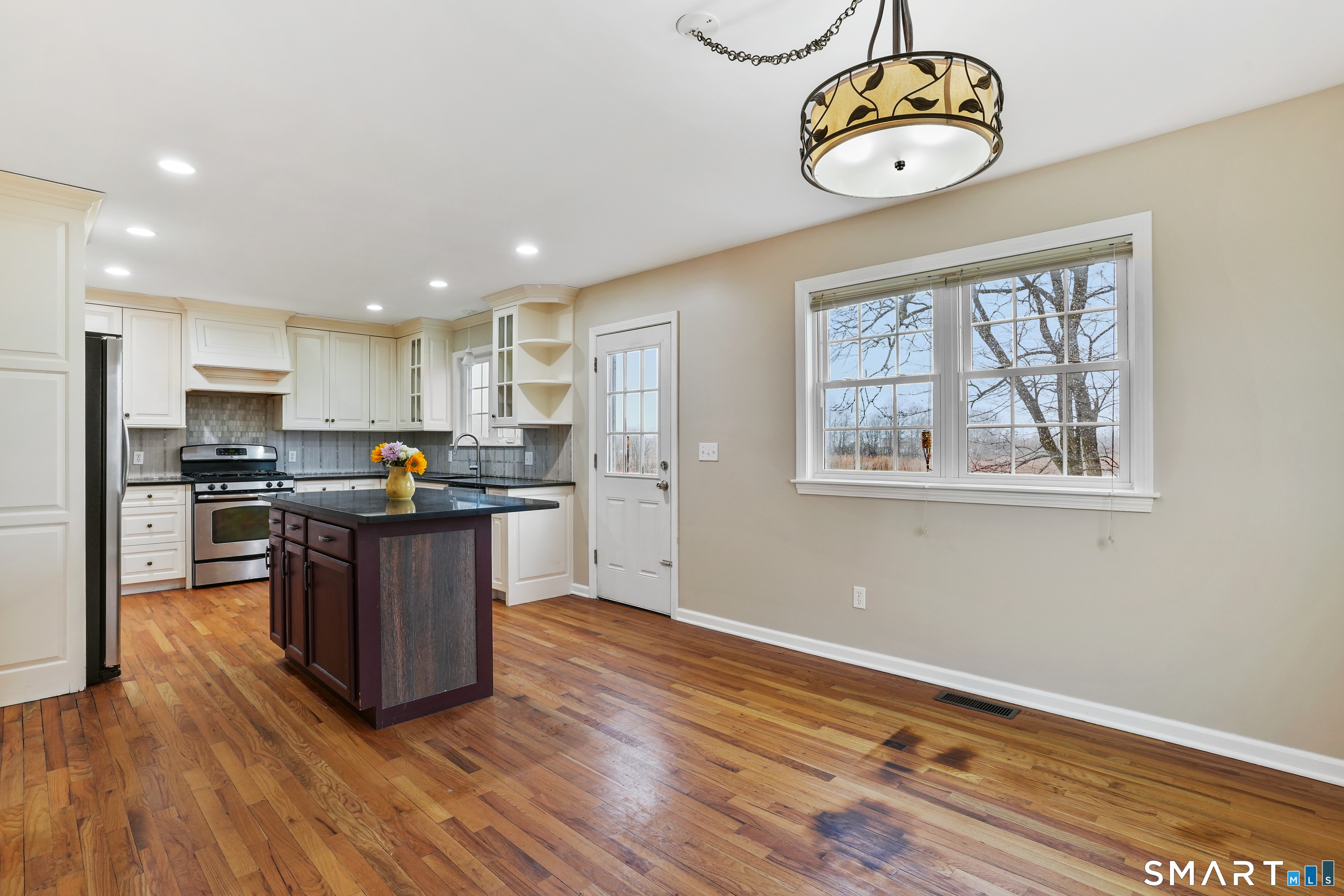 1180 Main Street Stratford, CT 06615 - Photo 6 of 22 a kitchen with a refrigerator wooden floor and a window