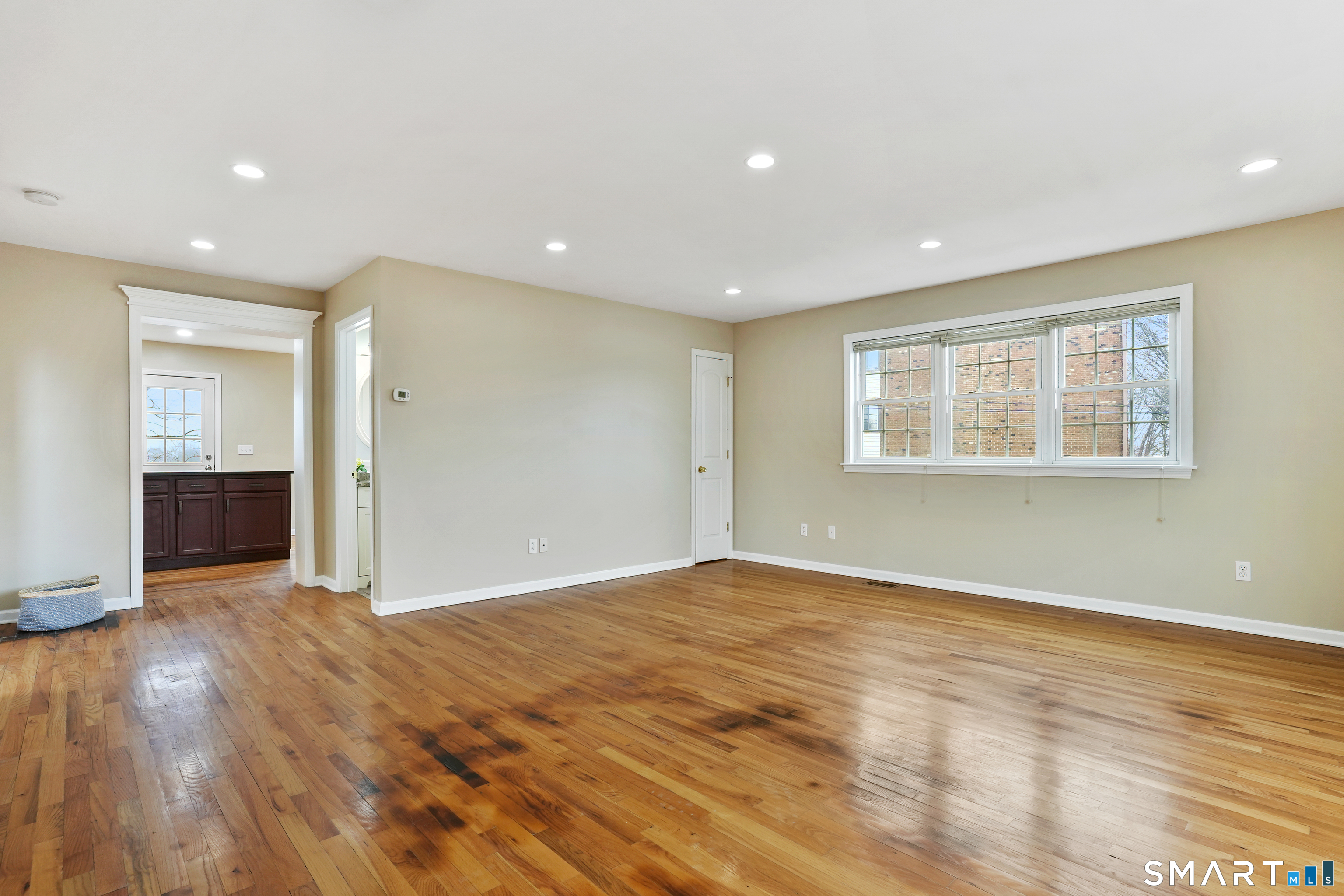 1180 Main Street Stratford, CT 06615 - Photo 9 of 22 a view of an empty room with wooden floor and a window