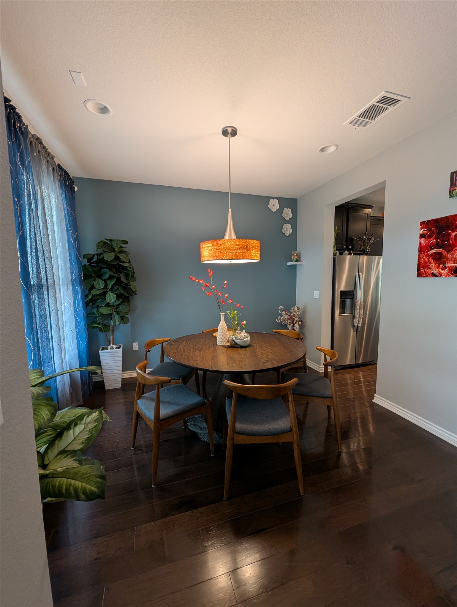 14502 McCoy Loop Austin, TX 78717 - Photo 9 of 26 Dining area featuring dark wood-finish flooring, a contemporary pendant light fixture, recessed ceiling lighting, and a window with sheer blue curtains