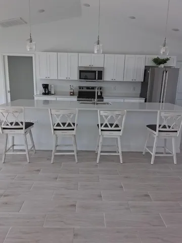 a kitchen with stainless steel appliances granite countertop a stove a sink and a microwave