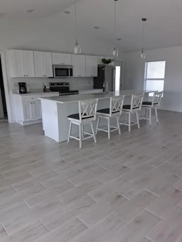 a view of kitchen with microwave and cabinets