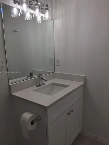 a bathroom with a sink vanity and a mirror
