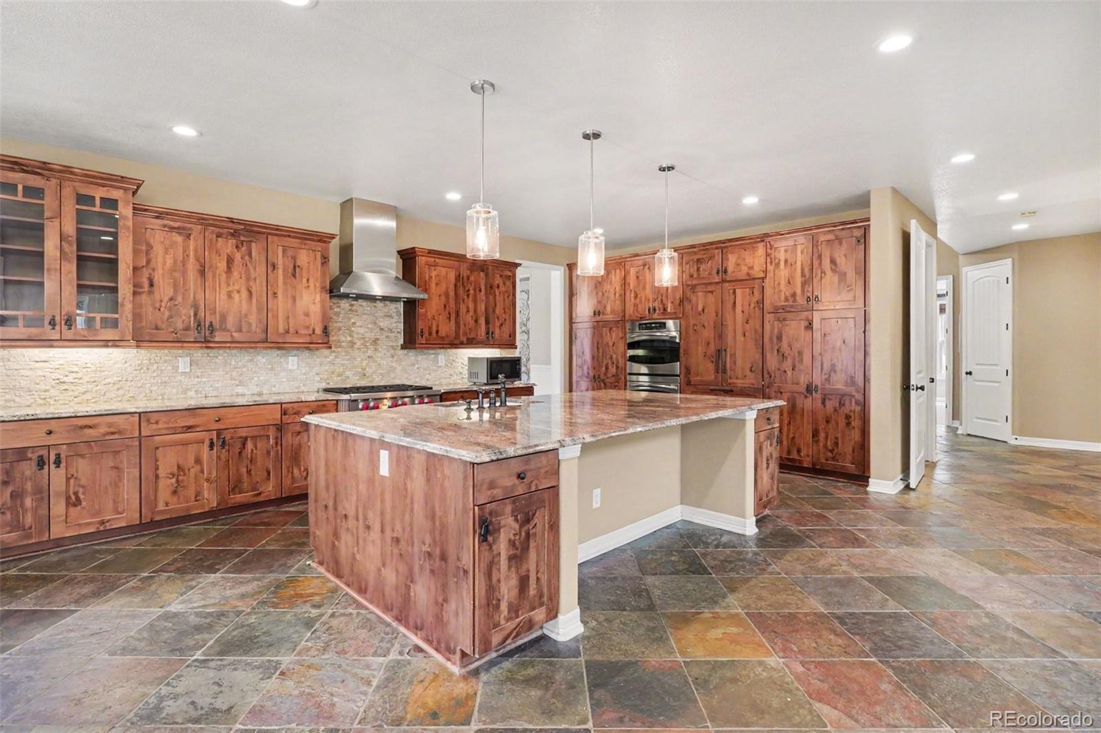 791 Elk Rest Road Evergreen, CO 80439 - Photo 11 of 46 a large kitchen with stainless steel appliances kitchen island granite countertop a stove a sink and a refrigerator