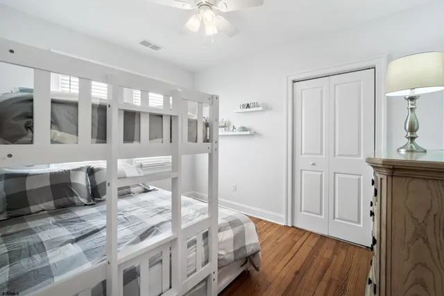 a view of a hallway with wooden floor and cabinet