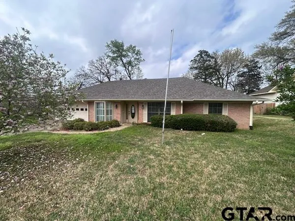 a view of a house with a yard and potted plants