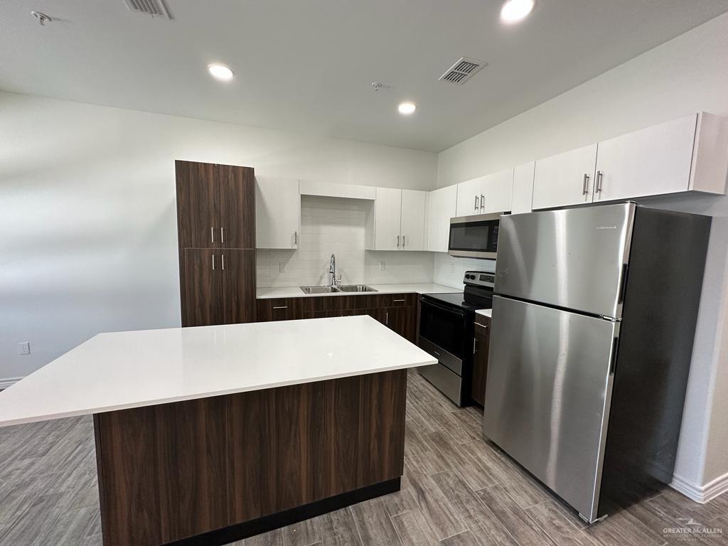 302 Sylvia Handy Drive, Unit B2 Elsa, TX 78543 - Photo 5 of 6 a kitchen with a refrigerator and a sink