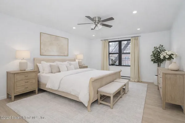 a spacious bedroom with a bed and a potted plant