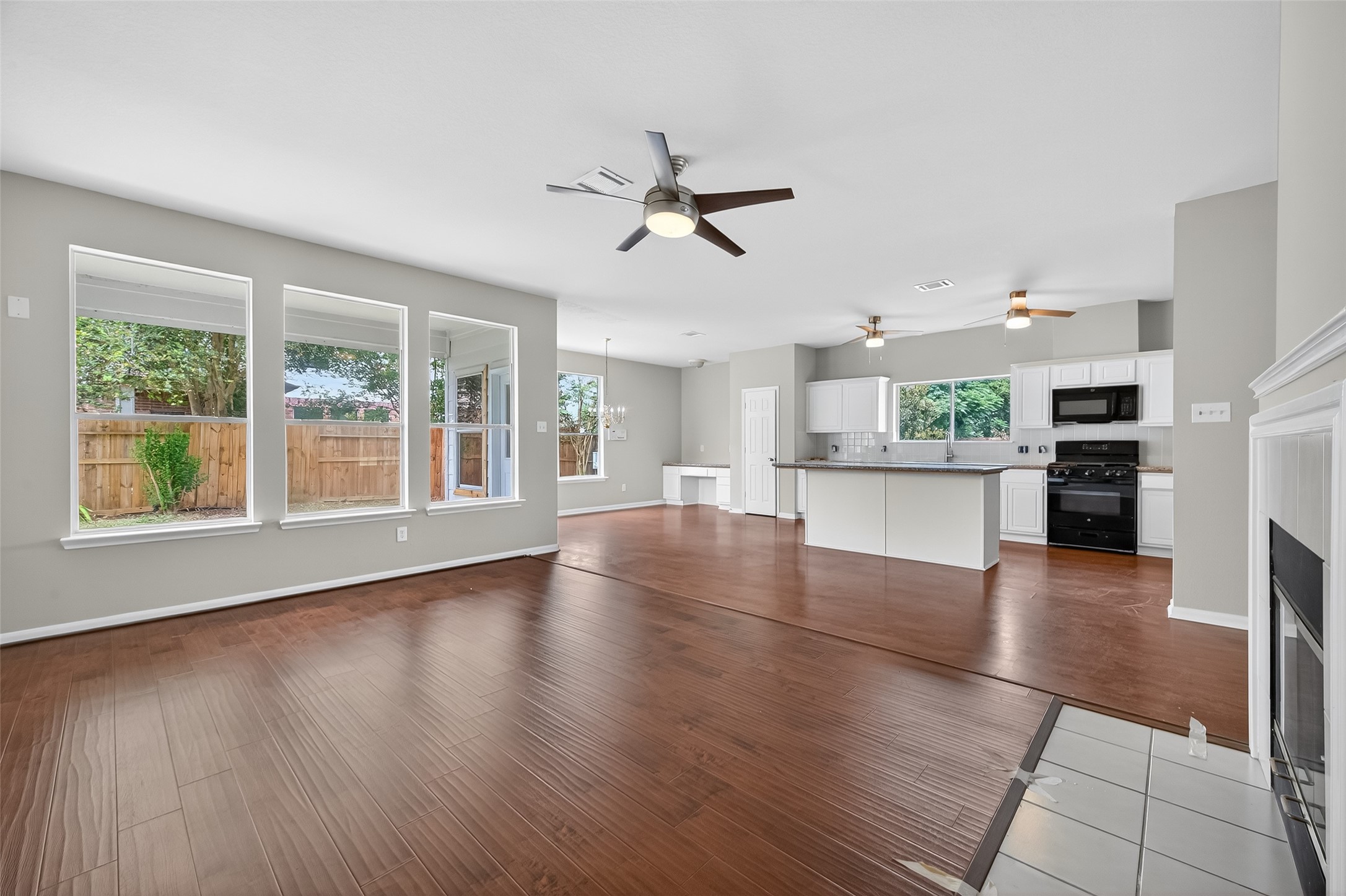 1302 Cross Draw Drive Houston, TX 77067 - Photo 8 of 35 a view of a kitchen with a stove cabinets a ceiling fan and wooden floor