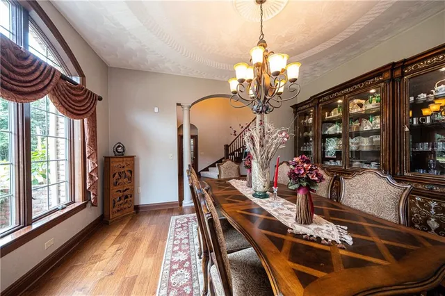 a very nice looking dining room with furniture a chandelier and large windows