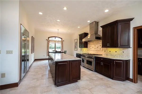 a large kitchen with stainless steel appliances granite countertop a stove and a sink