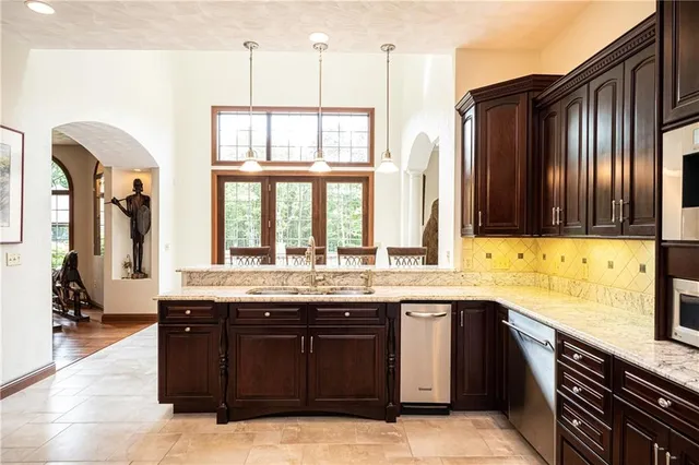 a kitchen with stainless steel appliances granite countertop wooden cabinets a sink and a dishwasher