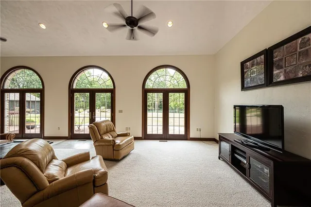 a living room with furniture a flat screen tv and a large window