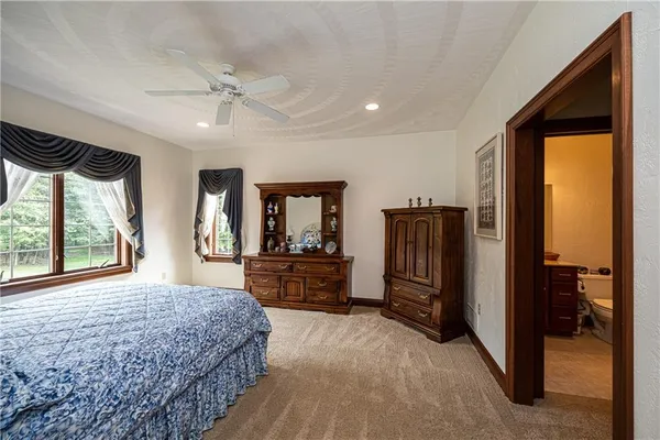 a bedroom with a bed and dresser with mirror