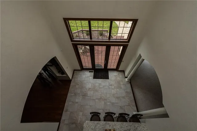 an entryway in a hall with wooden floor and a window