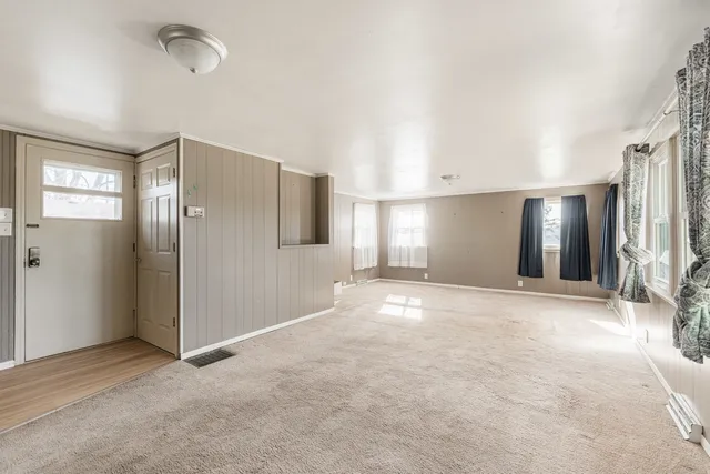 a view of an empty room with window and a bathroom