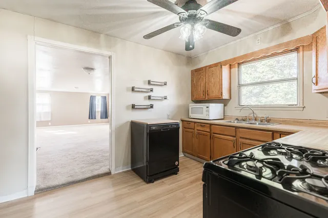 a kitchen with stainless steel appliances granite countertop a stove a sink and a microwave