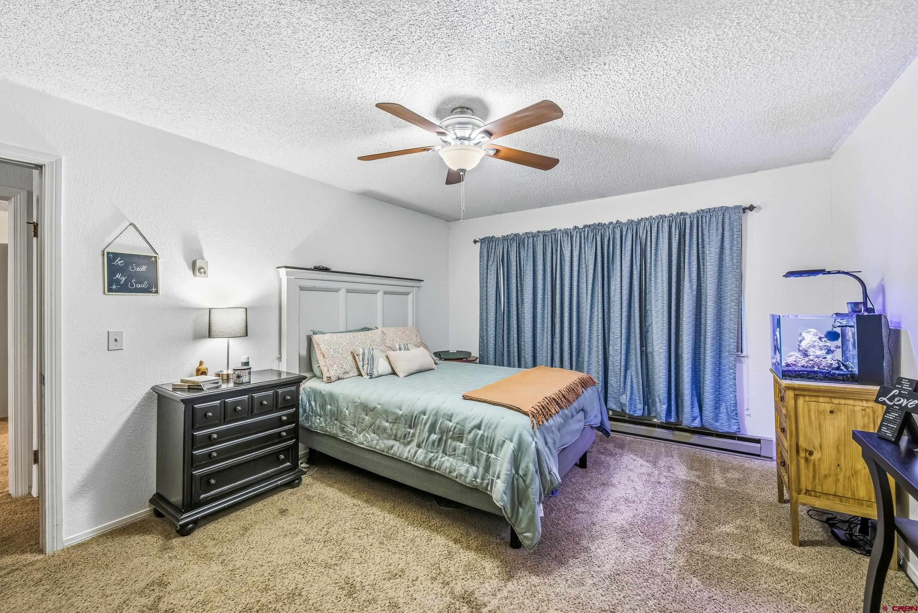 155 East 7th Street Delta, CO 81416 - Photo 12 of 19 a bedroom with a bed and a chandelier