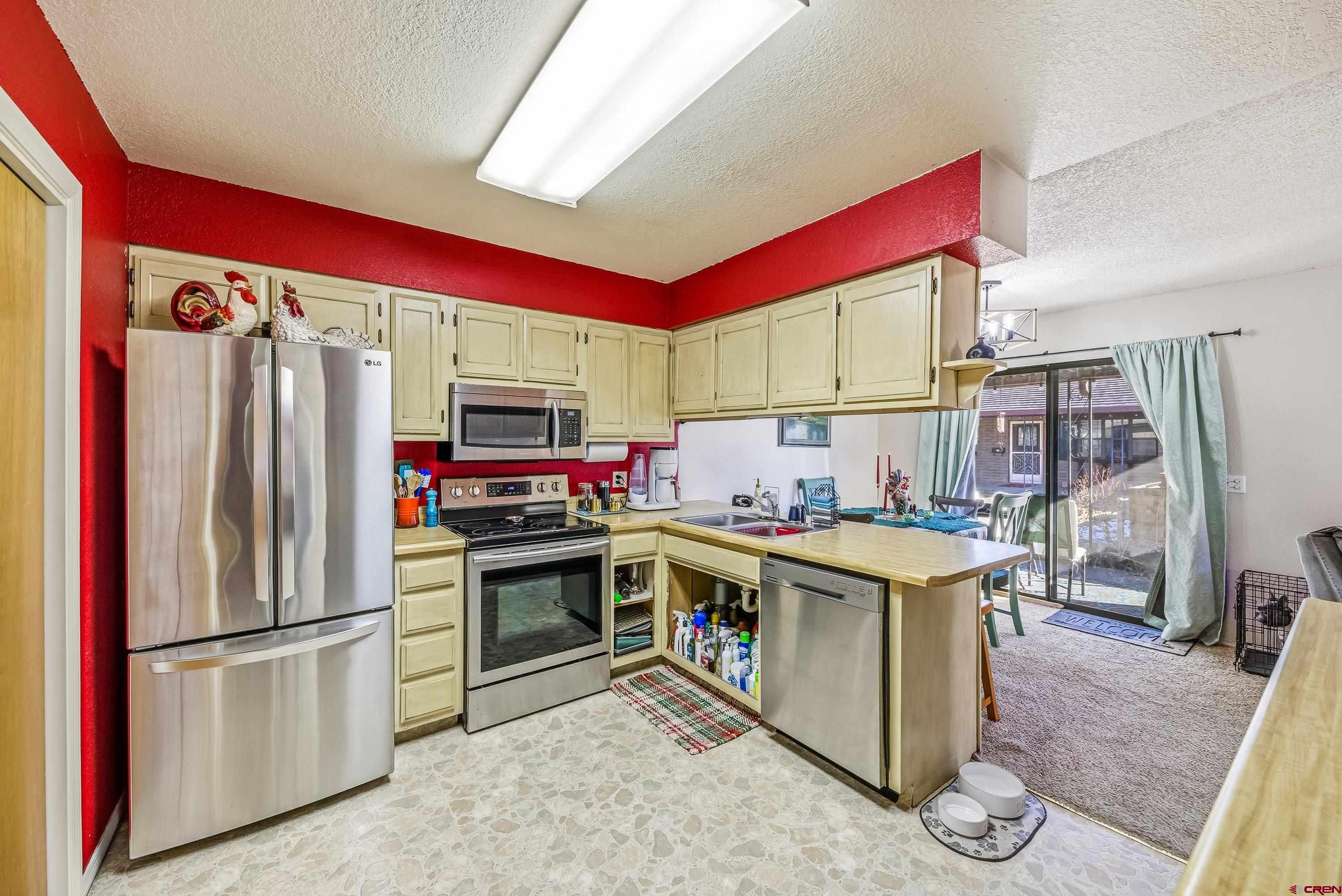 155 East 7th Street Delta, CO 81416 - Photo 7 of 19 a kitchen with stainless steel appliances granite countertop a refrigerator and a stove top oven