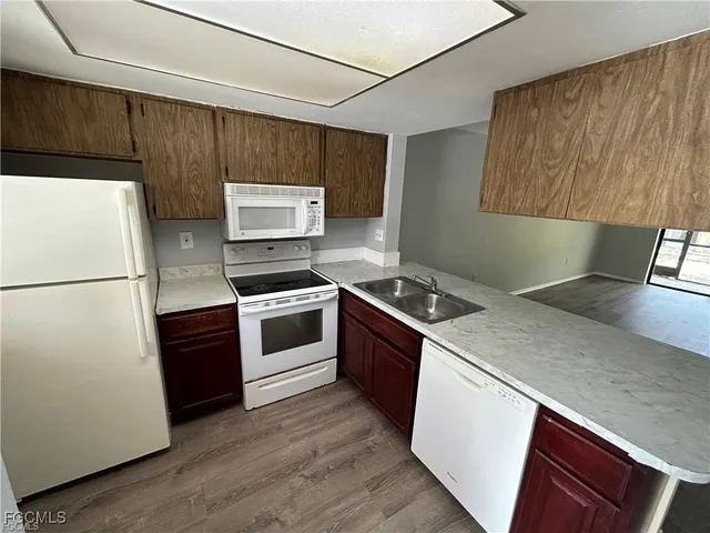 a kitchen with granite countertop a stove a sink and a refrigerator