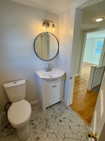 a bathroom with a sink toilet and mirror