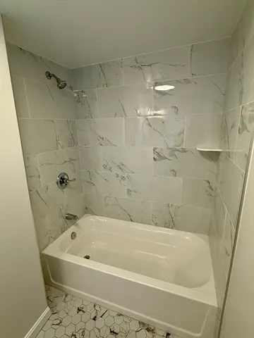 a bathroom with a bathtub and shower