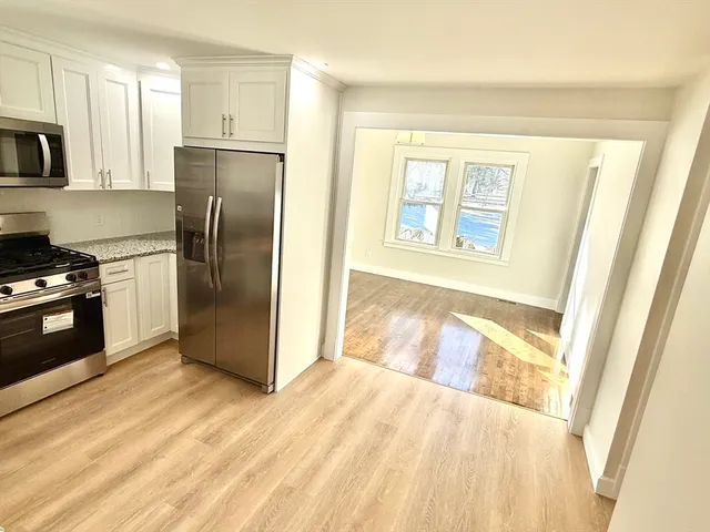 a kitchen with a refrigerator a stove top oven and cabinetry