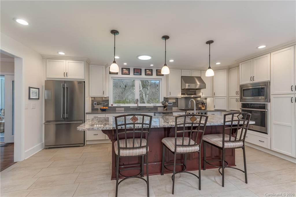 401 Laurel Ridge Road Columbus, NC 28722 - Photo 14 of 37 a dining area with furniture a large window and stainless steel appliances