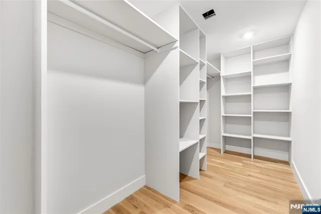 a view of walk in closet with empty racks