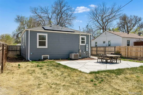 a view of a house with table and chairs in patio