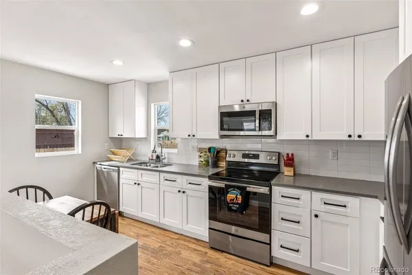 a kitchen with stainless steel appliances granite countertop a stove a sink dishwasher and a refrigerator