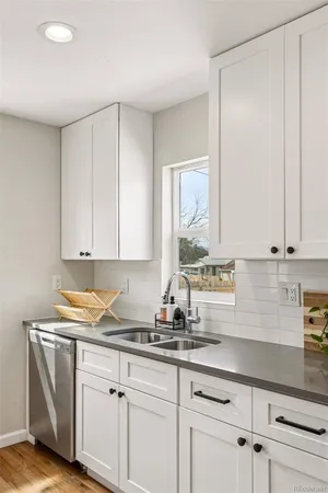 a kitchen with granite countertop white cabinets and white appliances
